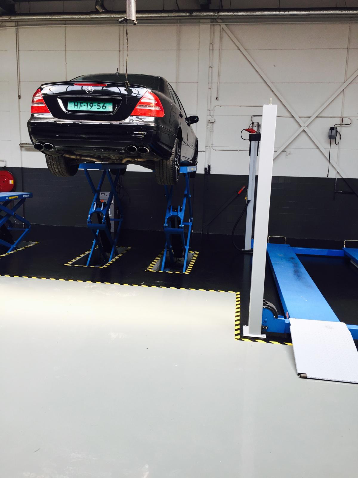 Mercedes op de schaarhefbrug in de werkplaats